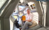 Dr inż. Przemysław Tabaka w module „Cupola” mobilnej repliki ISS, z publikacją poświęconą problematyce zanieczyszczenia światłem